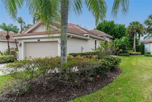 view of side of property with a lawn and a garage