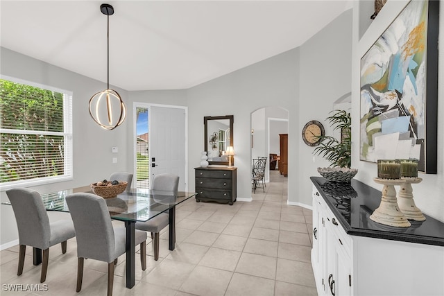 tiled dining space featuring vaulted ceiling