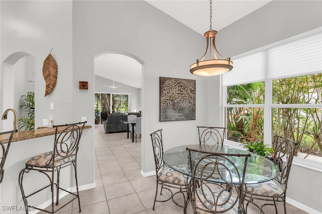 dining space featuring light tile patterned floors and vaulted ceiling