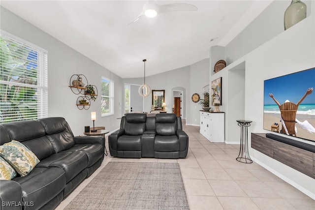 tiled living room with ceiling fan, a healthy amount of sunlight, and lofted ceiling