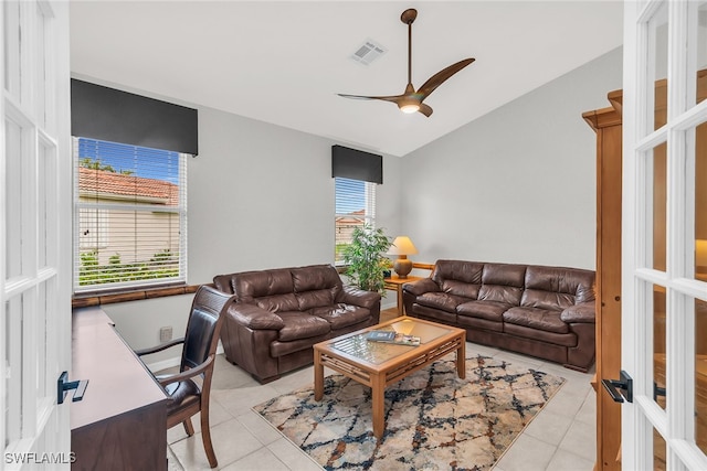 tiled living room featuring ceiling fan, vaulted ceiling, and french doors