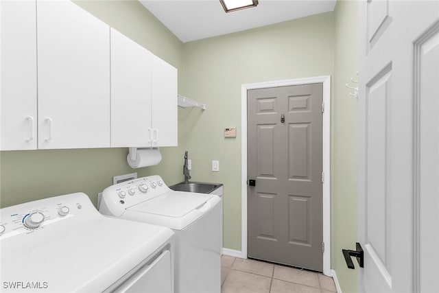 laundry room with cabinets, light tile patterned floors, washer and clothes dryer, and sink