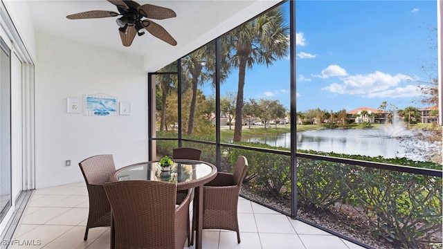 sunroom / solarium with ceiling fan and a water view