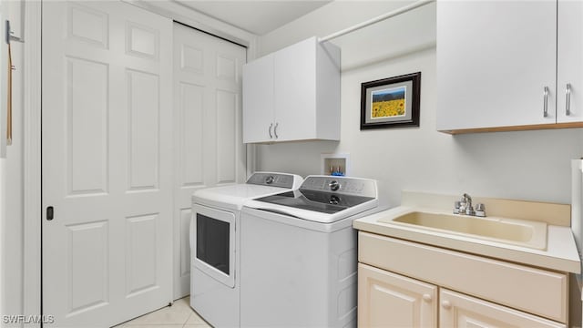 laundry room with cabinets, washing machine and dryer, sink, and light tile patterned floors