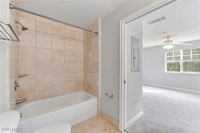 bathroom with tiled shower / bath combo, electric panel, toilet, and ceiling fan