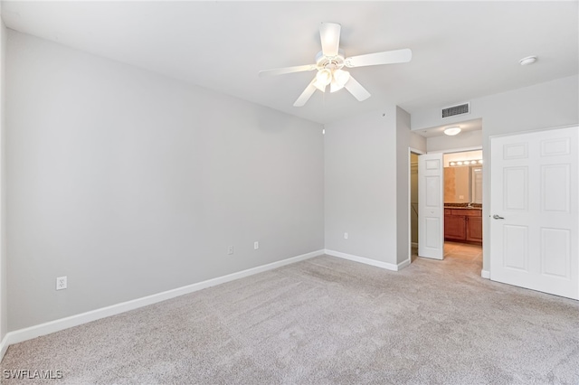 spare room featuring light colored carpet and ceiling fan