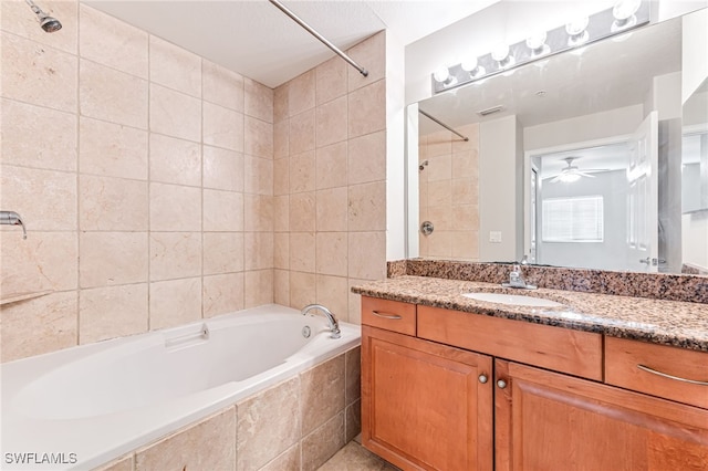 bathroom with ceiling fan, tiled shower / bath, and vanity