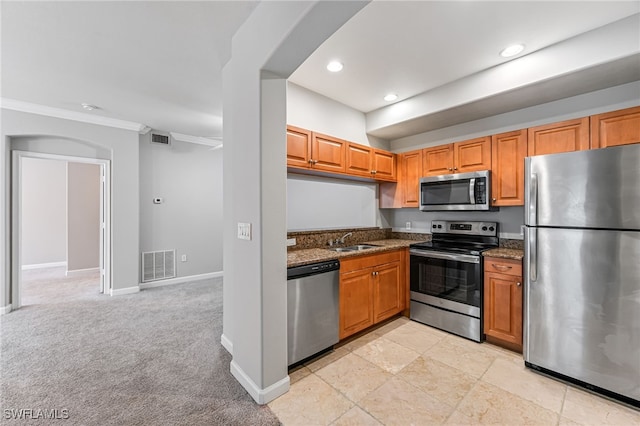 kitchen featuring dark stone countertops, sink, light colored carpet, and stainless steel appliances