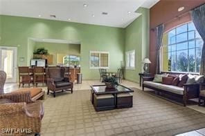 living room with light colored carpet and a high ceiling