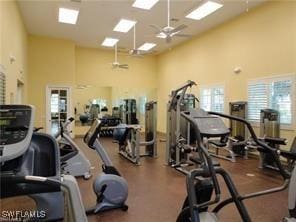 gym featuring a towering ceiling and ceiling fan