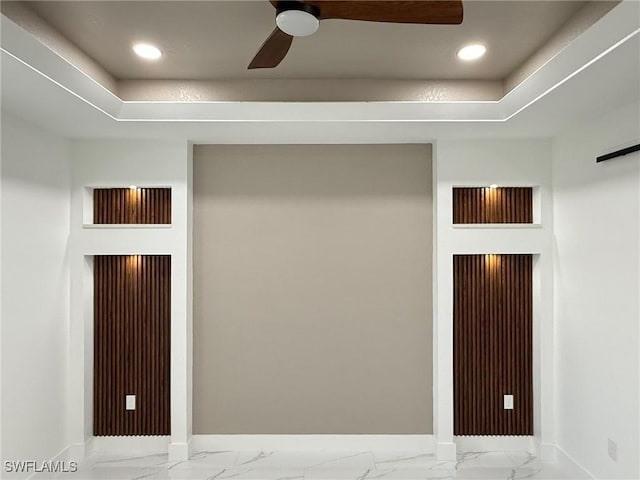 interior space with ceiling fan and a tray ceiling