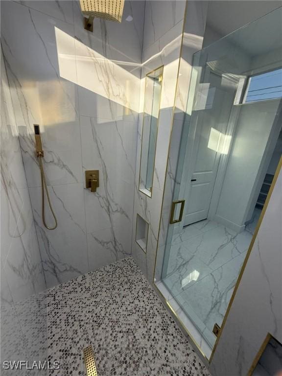 bathroom with a shower with door