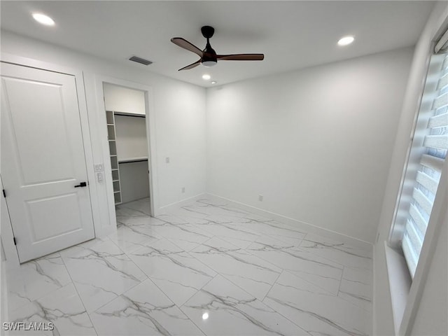 unfurnished bedroom featuring a walk in closet, ceiling fan, and a closet