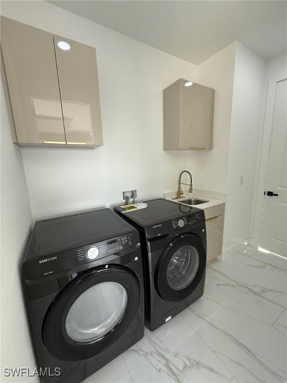 laundry area with separate washer and dryer and sink