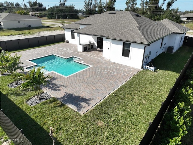 view of pool with a lawn, central air condition unit, and a patio area