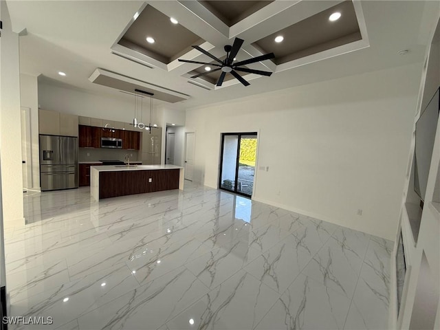 unfurnished living room featuring ceiling fan, coffered ceiling, beam ceiling, and a high ceiling