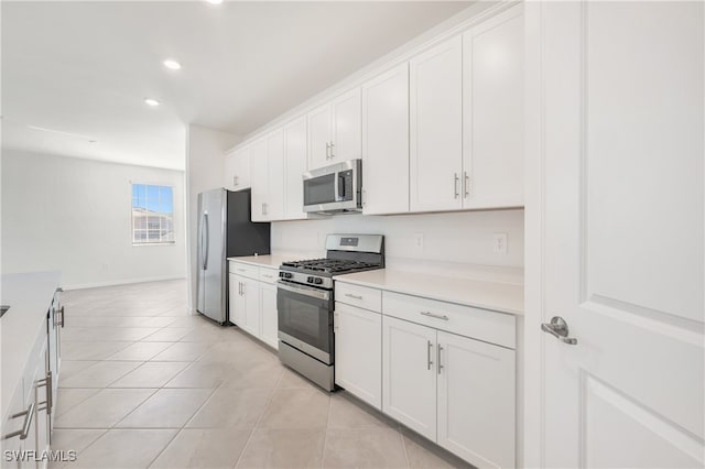 kitchen featuring white cabinets, stainless steel appliances, and light tile patterned flooring