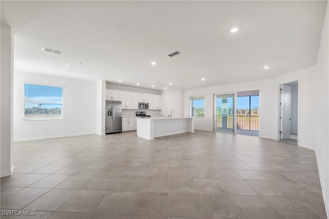 unfurnished living room with a wealth of natural light and light tile patterned floors