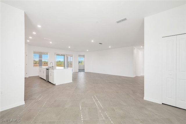 unfurnished living room with sink and light tile patterned flooring