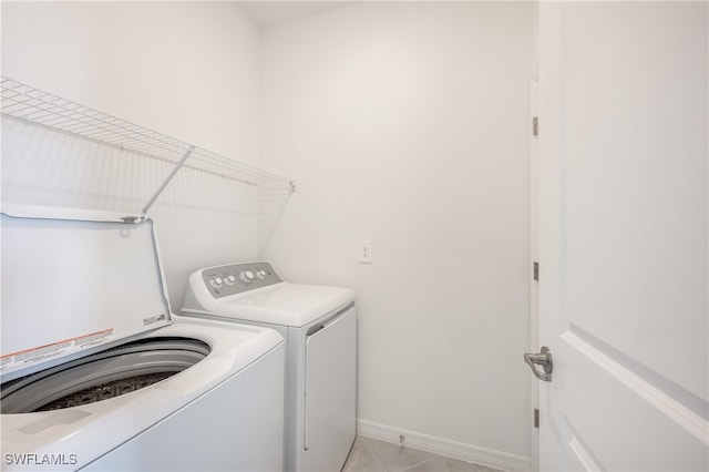 laundry room featuring washer and clothes dryer and light tile patterned flooring