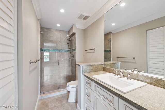 bathroom with tile patterned flooring, crown molding, toilet, a shower with door, and vanity