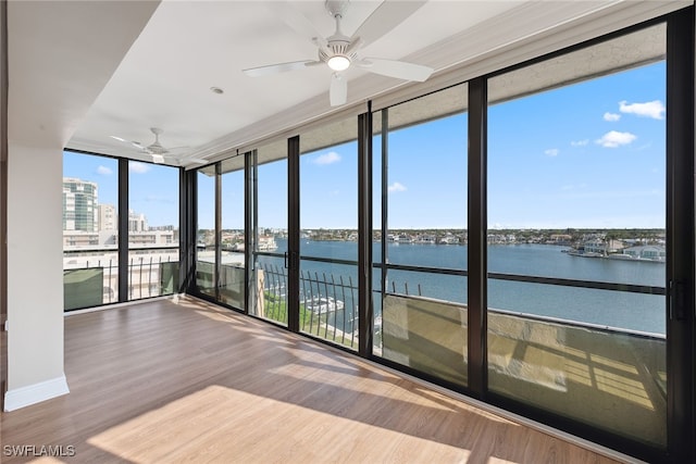 unfurnished sunroom with a water view and ceiling fan