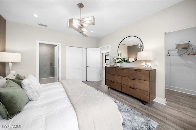 bedroom featuring connected bathroom and wood-type flooring