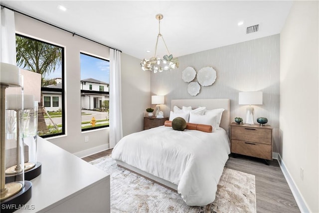 bedroom with light wood-type flooring and a notable chandelier