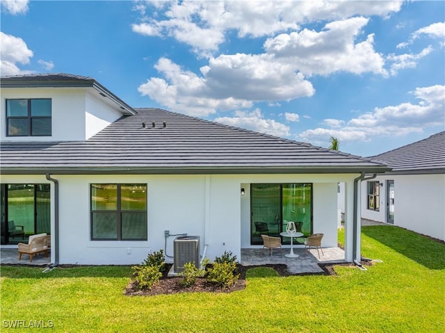 back of property featuring a yard, cooling unit, and a patio area