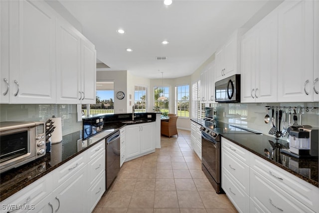 kitchen with white cabinetry, stainless steel dishwasher, black / electric stove, and light tile patterned flooring