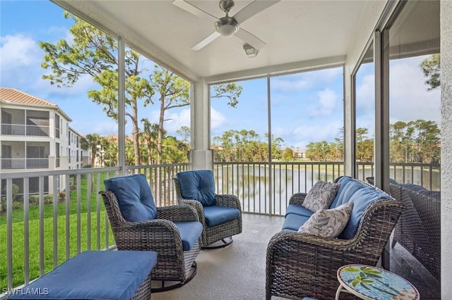 sunroom with ceiling fan and a water view