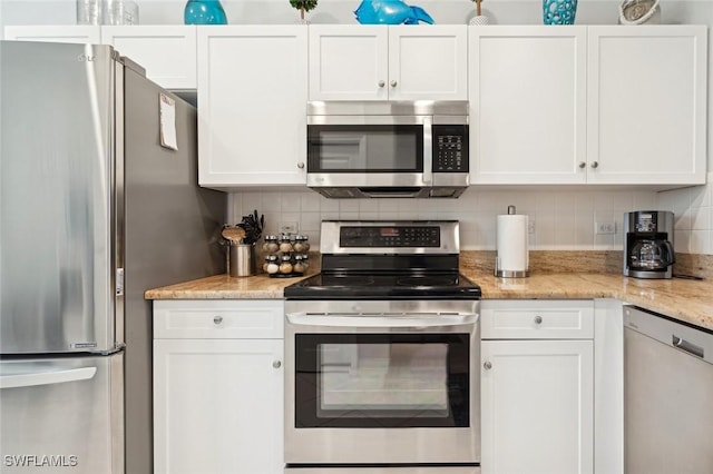 kitchen with light stone counters, white cabinetry, appliances with stainless steel finishes, and tasteful backsplash