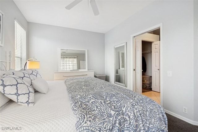 bedroom with ensuite bathroom, ceiling fan, a spacious closet, light colored carpet, and a closet