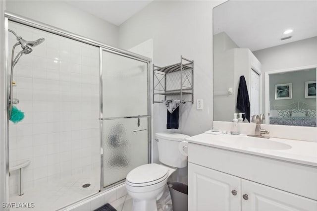 bathroom with vanity, a shower with shower door, and toilet