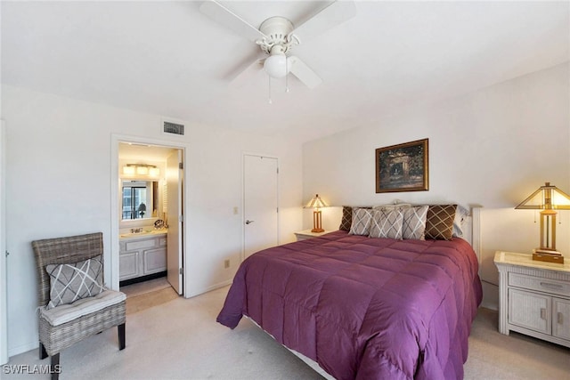 carpeted bedroom with ensuite bath and ceiling fan