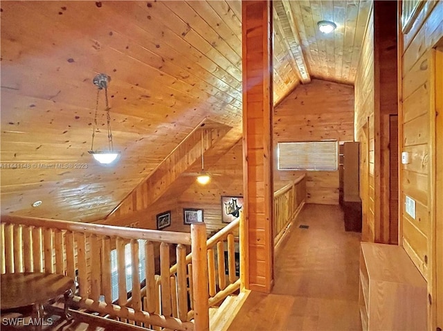 hall with wooden walls, hardwood / wood-style floors, wooden ceiling, and vaulted ceiling