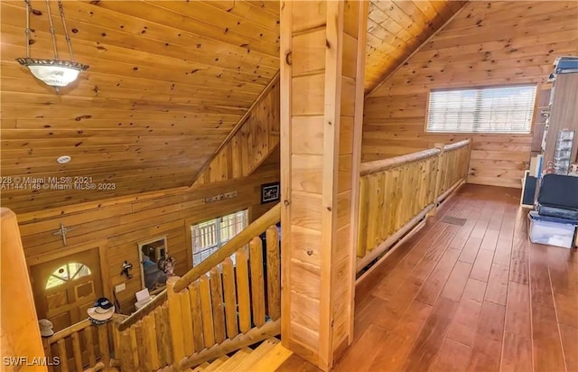 interior space featuring hardwood / wood-style flooring, lofted ceiling, wood walls, and wooden ceiling