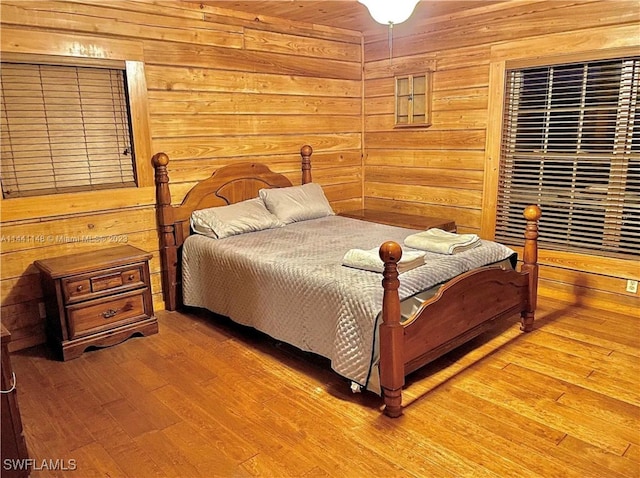 bedroom featuring hardwood / wood-style floors and wood walls