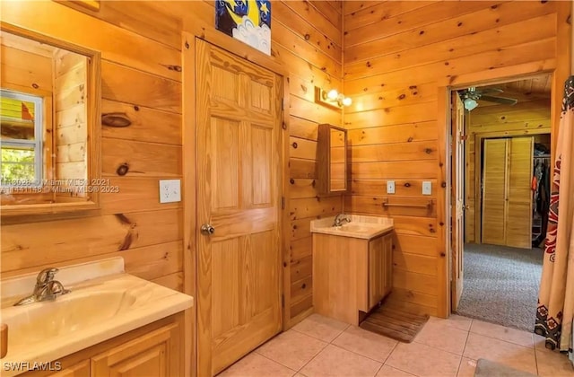 bathroom featuring vanity, tile patterned floors, ceiling fan, and wood walls