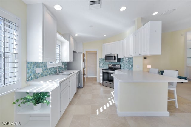 kitchen featuring white cabinets, stainless steel appliances, a wealth of natural light, and sink