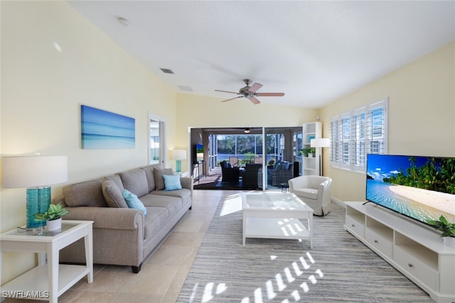 tiled living room with ceiling fan and vaulted ceiling