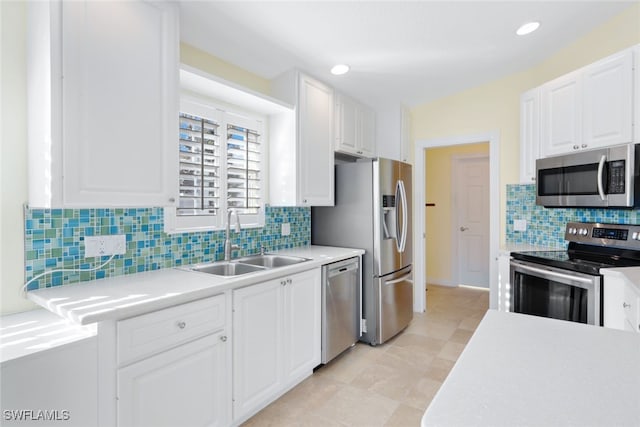 kitchen with sink, decorative backsplash, appliances with stainless steel finishes, light tile patterned flooring, and white cabinetry