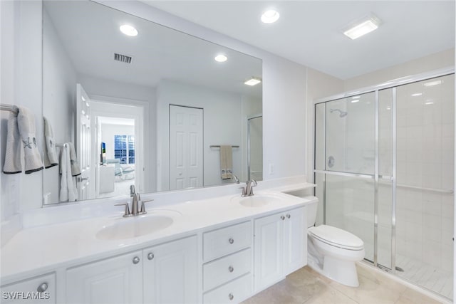 bathroom with tile patterned flooring, vanity, toilet, and a shower with shower door