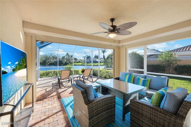 sunroom / solarium with a water view and ceiling fan