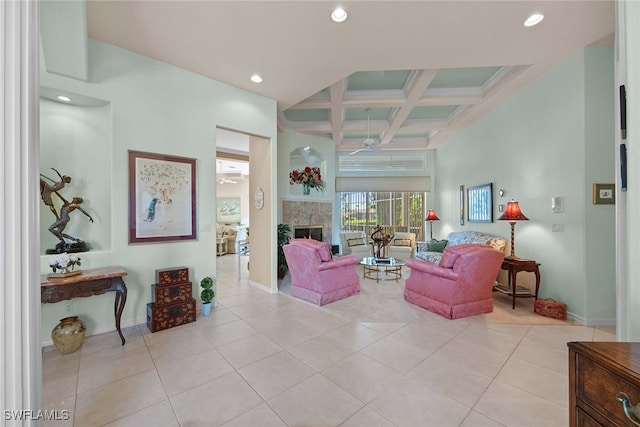 living room with a high end fireplace, coffered ceiling, ceiling fan, beam ceiling, and light tile patterned flooring