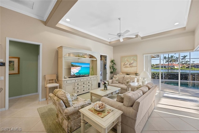 tiled living room featuring a tray ceiling, ceiling fan, and crown molding