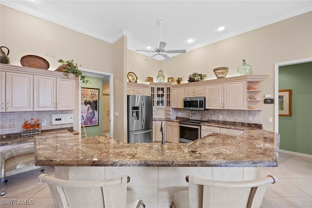 kitchen featuring a kitchen bar, light tile patterned flooring, and stainless steel appliances