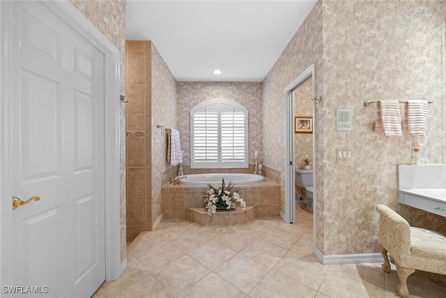 bathroom with tile patterned flooring, a relaxing tiled tub, and toilet