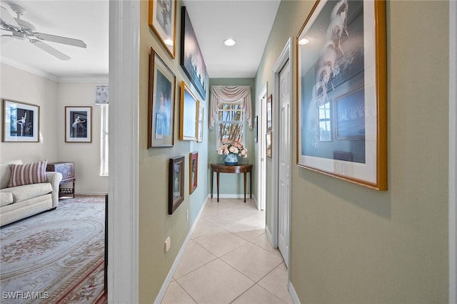 hallway with light tile patterned floors and crown molding