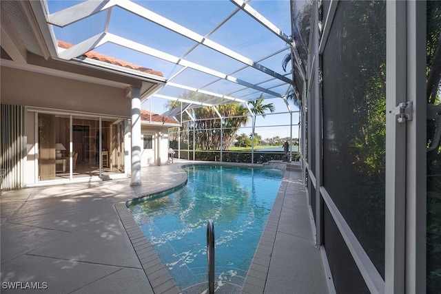 view of swimming pool featuring a lanai and a patio area